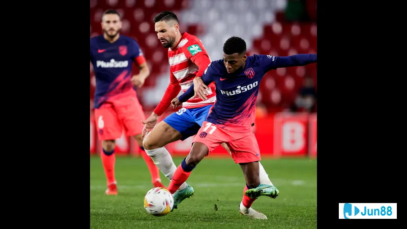 Hậu vệ của Rayo Vallecano cố gắng chặn đứng cú sút của tiền đạo Atletico Madrid